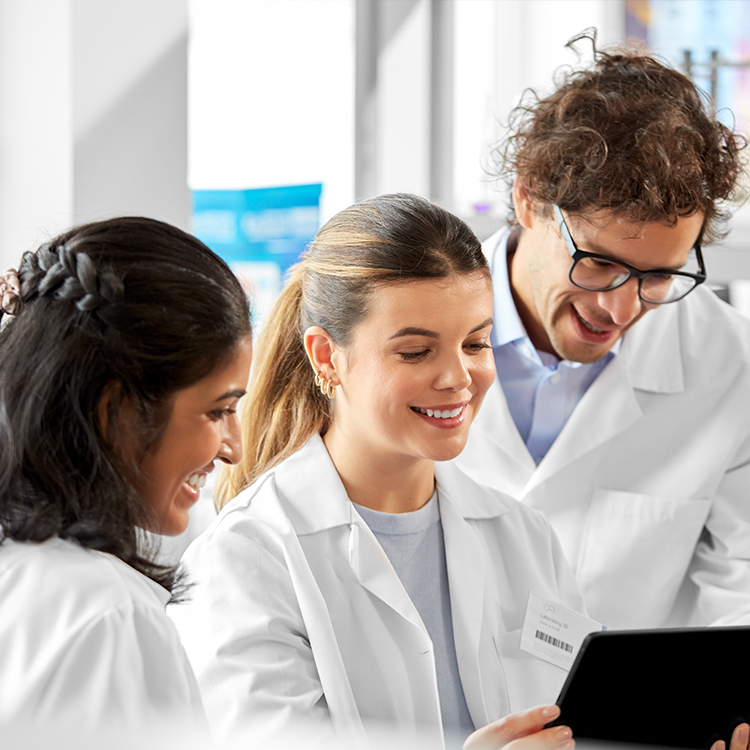 Diverse team of smiling scientists with tablet computer, working in laboratory environment